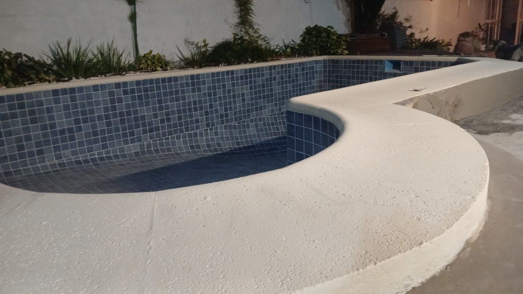 Piscina con venecitas azules y borde de piedra — Piscinas Aguas Claras
